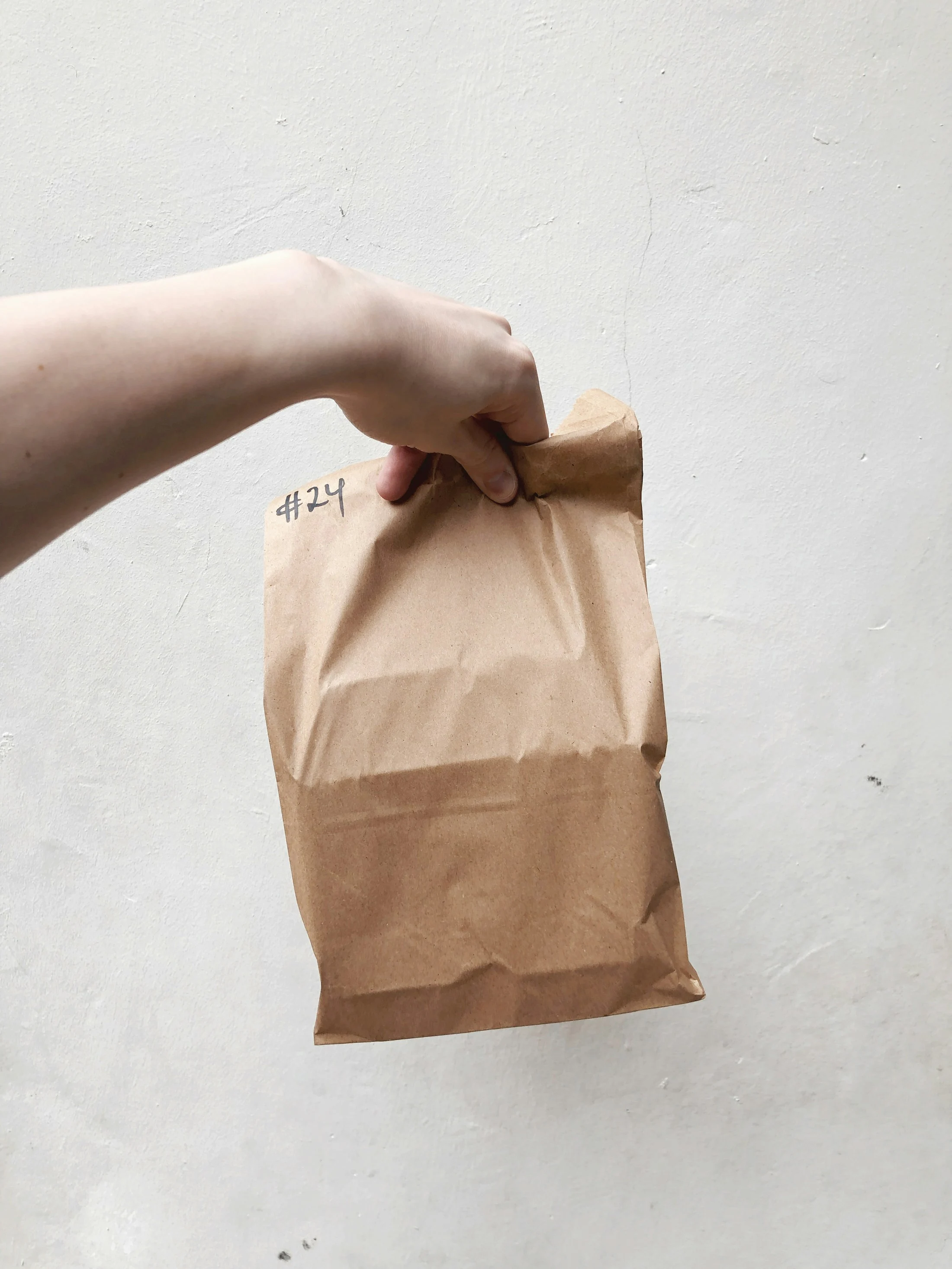 A paper delivery bag being carried by hand