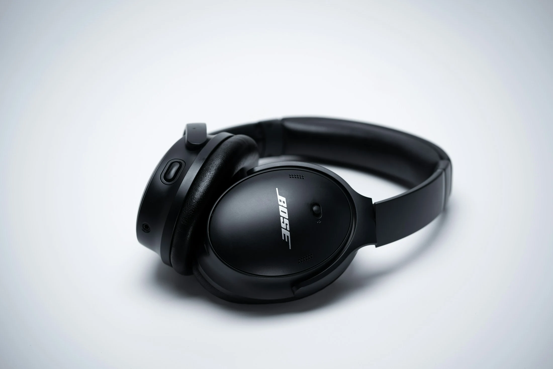 Black over-ear headphones resting on a pale surface
