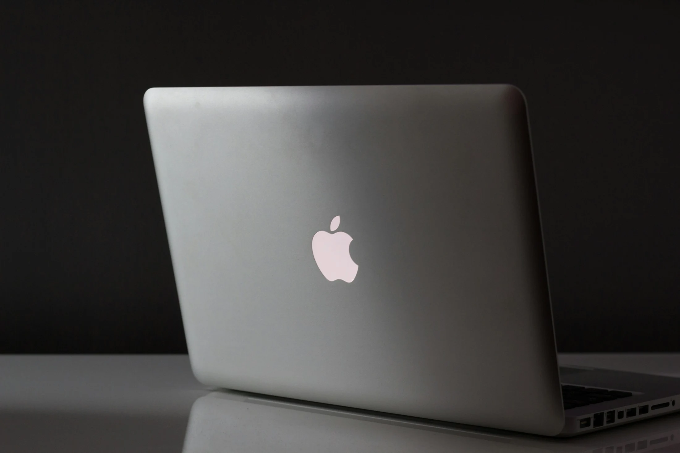 Silver laptop photographed on a dark desk