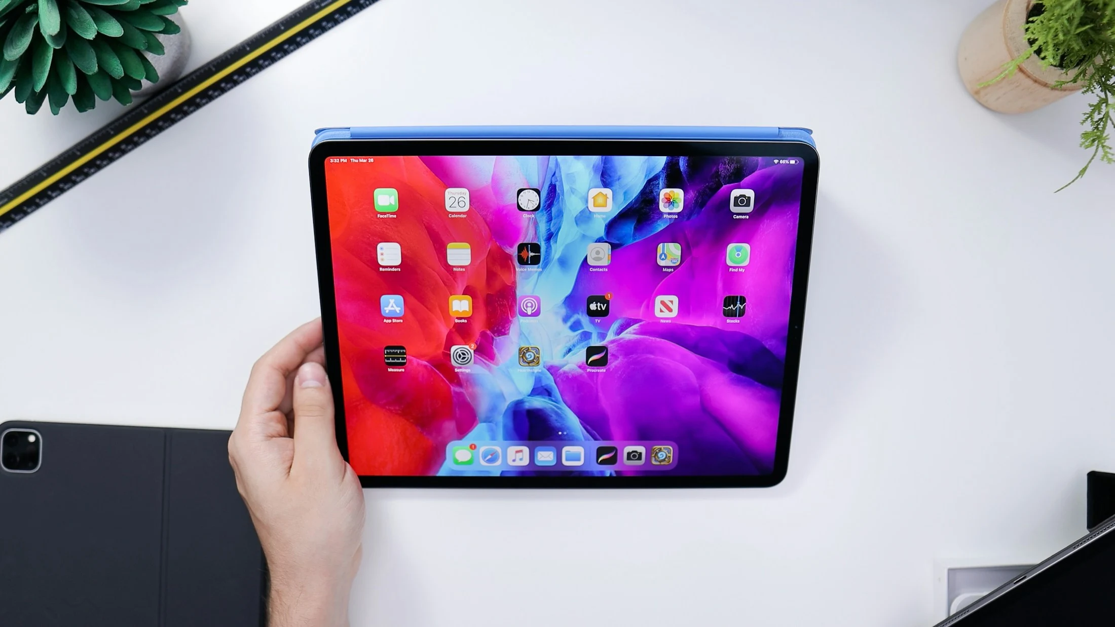 A tablet held above a white desk