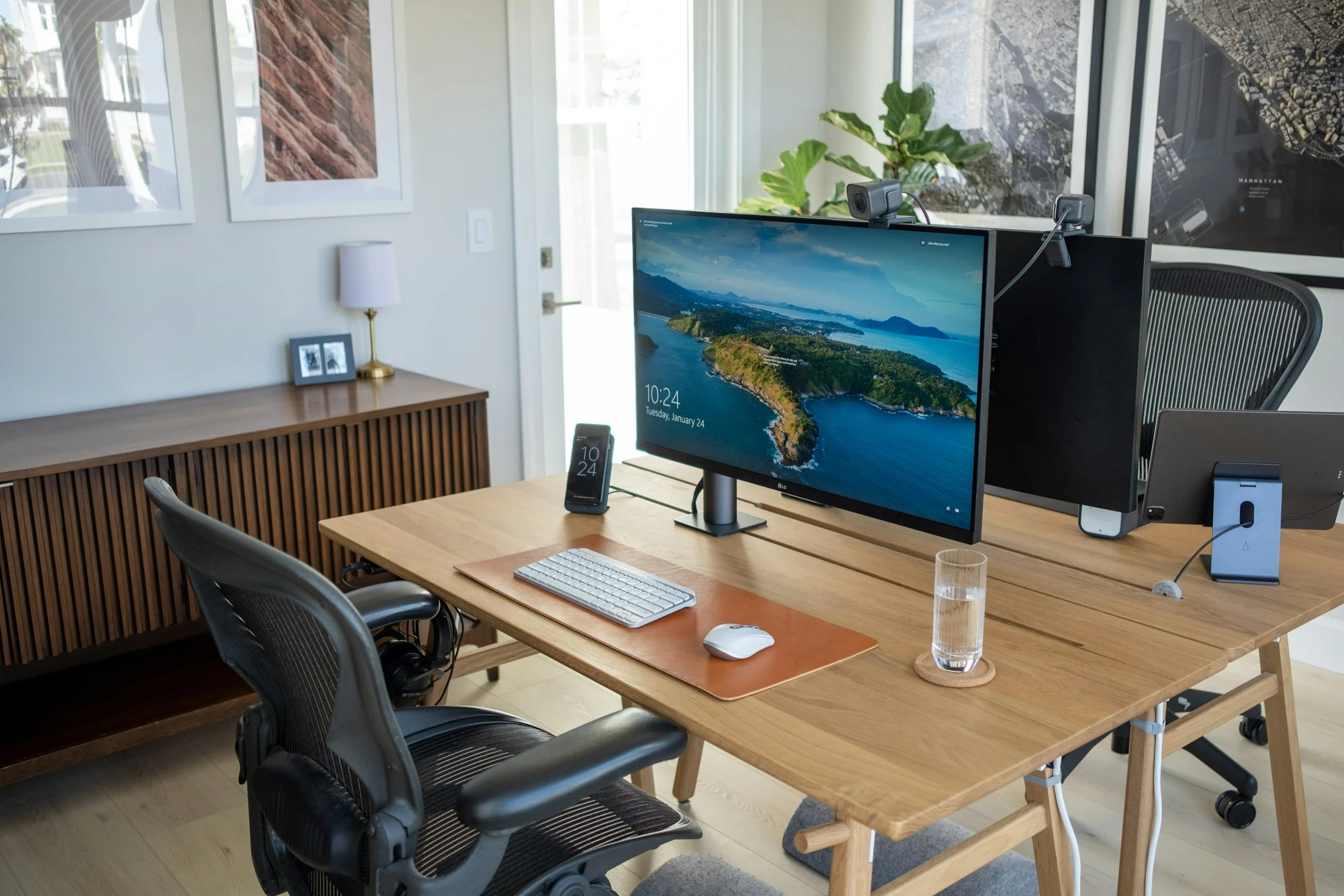 A light-filled home workspace with a monitor on a timber desk